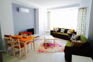 een woonkamer met een tafel en een bank bij Modern Suites in Antalya