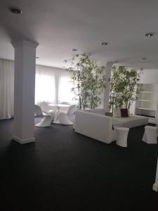 Cette chambre est dotée d'un mobilier blanc et de plantes en pot. dans l'établissement Hotel Costa de Prata 2 & Spa, à Figueira da Foz