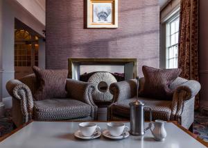 a living room with two chairs and a fireplace at The White Lion Hotel in Aldeburgh
