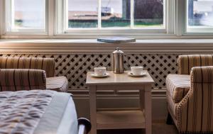 a room with two chairs and a table with two cups at The White Lion Hotel in Aldeburgh
