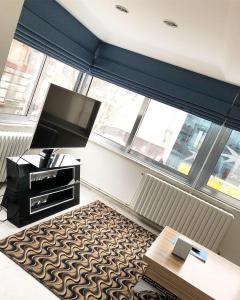 a living room with a tv and a large window at My Kent Hotel in Istanbul