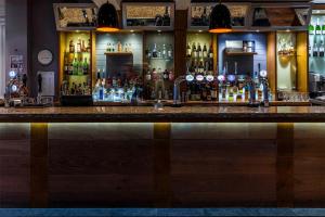 a bar with a lot of bottles of alcohol at The White Lion Hotel in Aldeburgh