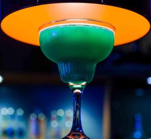 a green drink in a martini glass with a light at The White Lion Hotel in Aldeburgh