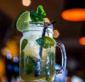 a mason jar with a green drink with a lime at The White Lion Hotel in Aldeburgh