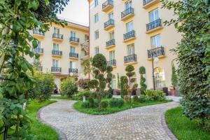 a building with a path in front of it at LOTTE City Hotels Tashkent Palace in Tashkent