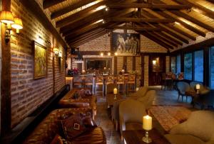 a living room with couches and tables and a bar at Manici Kasri in Küçükkuyu