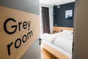 a bedroom with a bed and a sign that says grey room at Yard Hostel & Coffee in Chernivtsi