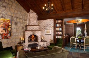 a living room with a brick fireplace and a couch at Manici Kasri in Kucukkuyu