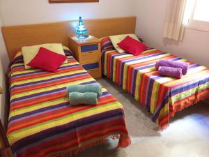1 dormitorio con 2 camas con mantas y almohadas coloridas en Luxury Flat, en Málaga