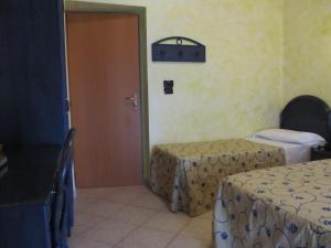 una camera con due letti e una porta di Hotel L'Approdo ad Anzio