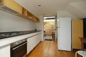 a kitchen with a white refrigerator and a wooden floor at Pacific Terraces 16, 38 Pacific Street in Crescent Head