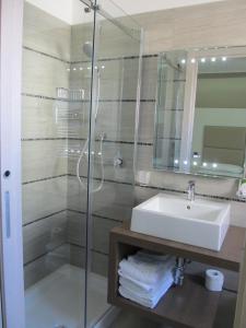 La salle de bains est pourvue d'un lavabo et d'une douche en verre. dans l'établissement Hotel L'Approdo, à Anzio