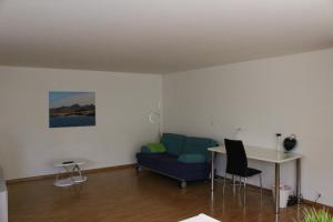 ein Wohnzimmer mit einem blauen Sofa und einem Tisch in der Unterkunft A Casa Fina- a modern room close to Basel in Therwil
