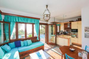 a living room with a blue couch and a kitchen at Achladies Beach Apartment in Skiathos