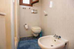 a bathroom with a white toilet and a sink at Achladies Beach Apartment in Skiathos