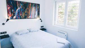 a bedroom with a bed and a painting on the wall at APARTAMENTO ROMANTICO FREE PARKING AREA WIFi in San Sebastián