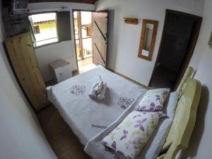 un dormitorio con una cama con un animal de peluche en Pousada e Chalés Itamoara, en São Thomé das Letras