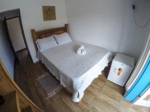 Un dormitorio con una cama con un osito de peluche. en Pousada e Chalés Itamoara, en São Thomé das Letras