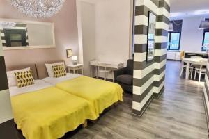 - une chambre avec un lit jaune et une salle à manger dans l'établissement St.Roland Livu Square, à Riga