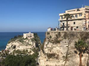 a building on a cliff next to the ocean at Residenza Corallina in Tropea