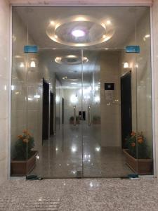 a reflection of a hallway in a building with a mirror at Etlalet Al-Sharm Apartments in Yanbu