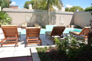a group of chairs sitting next to a swimming pool at Mercedes Park Hotel in Villa Mercedes