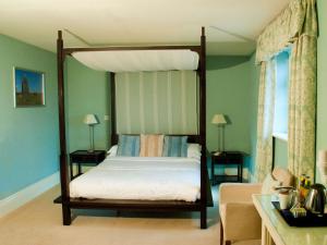1 dormitorio con cama con dosel y sala de estar. en Beansheaf Hotel en Pickering