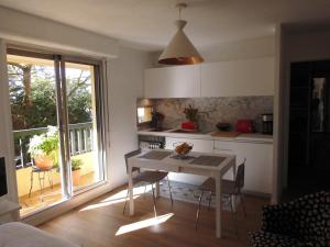 uma cozinha com uma mesa com cadeiras e uma janela em Au balcon fleuri em Anglet