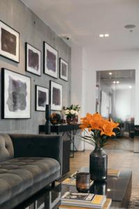 a living room with a couch and a table with orange flowers at Sand Hotel by Keahotels in Reykjavík