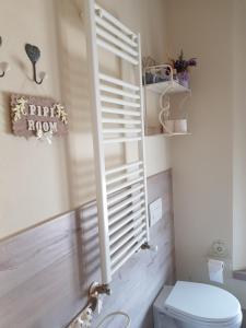 a bathroom with a toilet and a window with blinds at Luna City in Ravenna