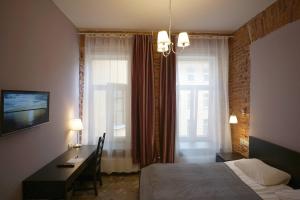 a bedroom with a bed and a desk and a window at Select in Saint Petersburg