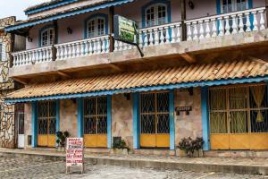 un edificio con una señal delante de él en Pousada e Chalés Itamoara, en São Thomé das Letras