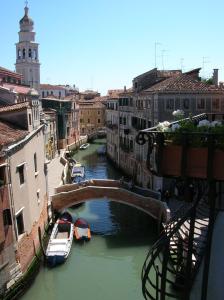 un puente sobre un canal en una ciudad con barcos en B&B S.Marco, en Venecia