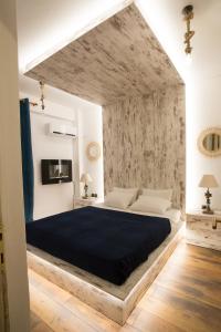 a bedroom with a large bed with a blue blanket at Thess Nature Apartment in Thessaloniki