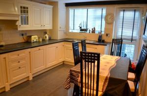 a kitchen with a table and chairs and a counter top at Justa Cottage in Shaldon