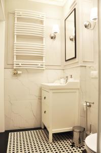 a white bathroom with a sink and a mirror at Rakowicka 22H - studio by Homeprime in Kraków