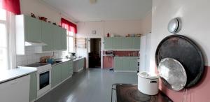 una cocina con armarios verdes y rosados en Hirvaskosken kartano, en Sotkajärvi