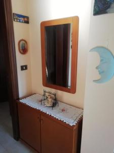 a bathroom with a mirror on top of a dresser at La Casa dei Gelsomini in Arsiero