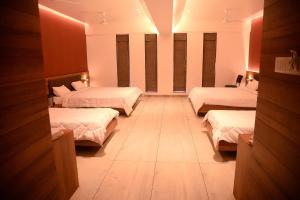een hotelkamer met drie bedden in een kamer bij The Bliss Hotel in Somnath