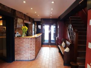 a bar in a restaurant with a brick wall at The Crown at Wells, Somerset in Wells