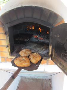 due bagel stanno cuocendo in un forno di mattoni di Nova Alofa holiday home a Monchique
