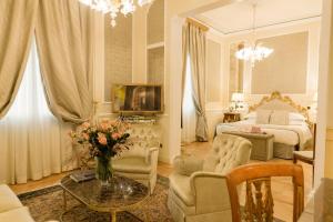 a living room with a bed and a couch and a table at Grand Hotel Majestic gia' Baglioni in Bologna +155 photos