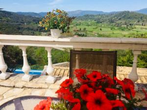 een balkon met een tafel met bloemen erop bij Ermones Ruby Villa in Vátos