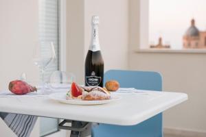 a table with a plate of food and a bottle of wine at CIELO D' ALCAMO Palazzo Adamo in Alcamo