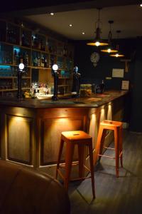 a bar with two stools in a room at Ty Glyndwr Bunkhouse, Bar and cafe in Caernarfon