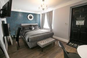 a bedroom with a bed and a chair and a chandelier at Number 82 The Unthank in Norwich
