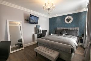 1 dormitorio con cama, espejo y lámpara de araña en Apartments at Number 82 The Unthank en Norwich