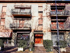 un edificio con 2 balcones y una puerta roja en Guest House Vecchi, en Reggio Emilia