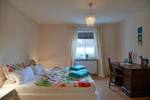 Schlafzimmer mit einem Bett, einem Schreibtisch und einem Fenster in der Unterkunft Ferienwohnung am Benther Berg in Gehrden