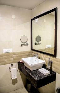 a bathroom with a sink and a large mirror at Gold Stone Comfort in Dehradun